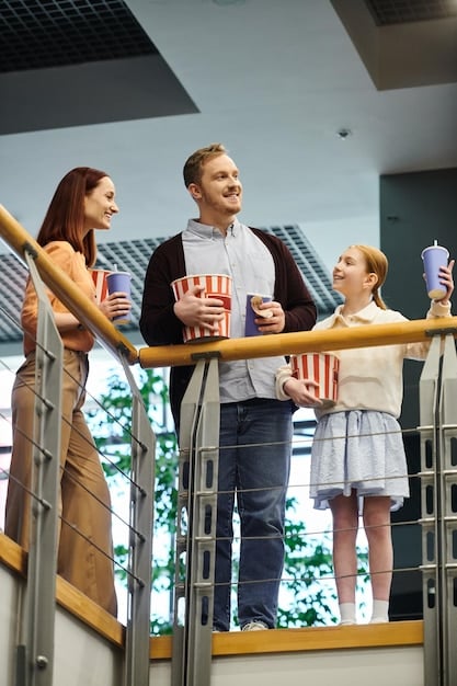A bustling movie theater lobby with people buying tickets and snacks, excited to watch a summer blockbuster film.