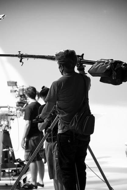 A behind-the-scenes shot of a film crew using a Steadicam. The image shows the camera operator wearing the Steadicam harness and smoothly moving the camera while filming a scene. This visual illustrates the technical complexity and skill involved in achieving fluid camera movements.
