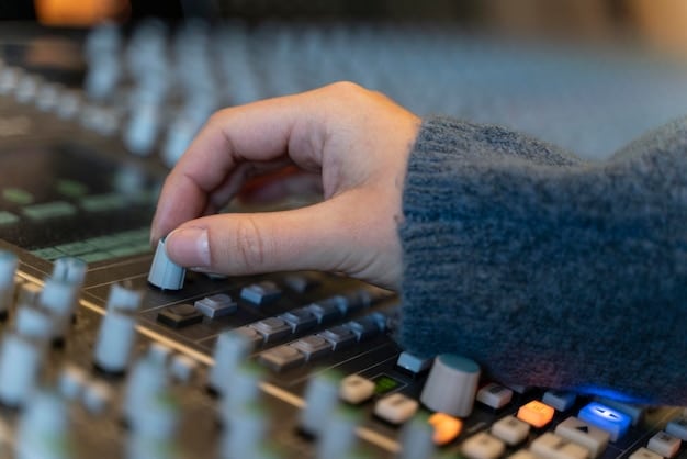 A close-up of a musician's hands adjusting the knobs on audio mixing equipment, with a computer screen displaying music editing software in the background. The focus is on the intersection of creativity and technology in music production.
