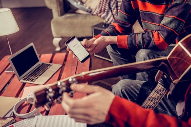 A musician using a laptop and smartphone to manage their gig applications and social media promotion.
