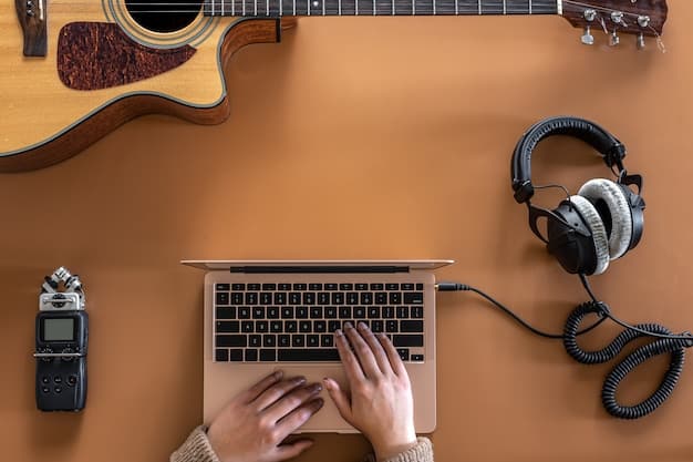 A musician working on a laptop in a home studio, surrounded by musical instruments and recording equipment. The laptop screen displays social media analytics dashboards, showing engagement metrics and audience demographics.