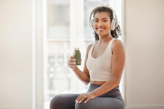 A candid shot of a celebrity holding a healthy green smoothie after a workout, with visible gym equipment in the background. The lighting should be bright and natural.