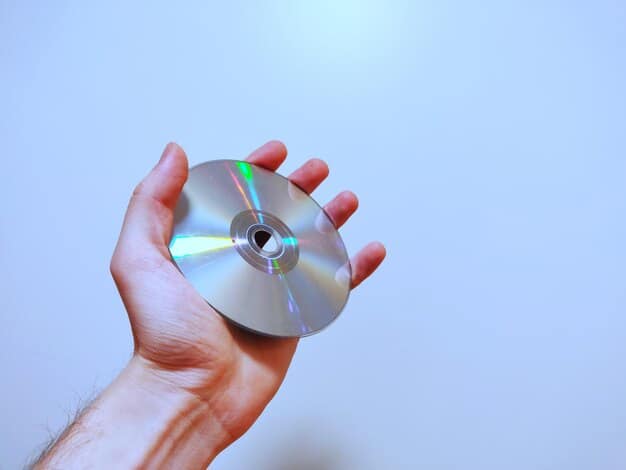 A person's hand holding a 4K Blu-ray disc, displaying the holographic security feature, hinting at the premium quality and authenticity of the physical media.